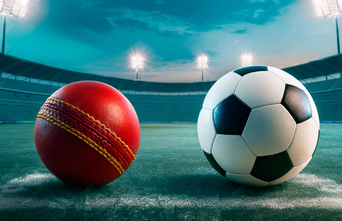 Cricket ball and soccer ball on a stadium field under bright floodlights